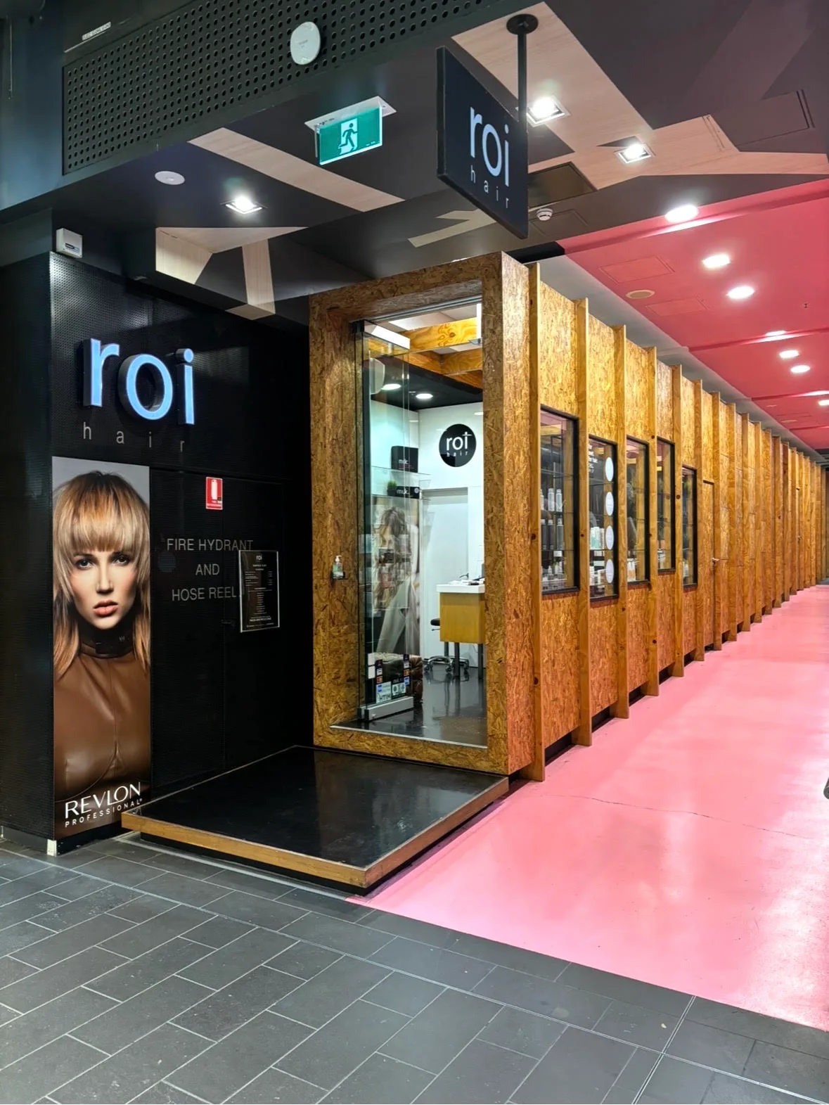 The Roi Hair shopfront on the ground floor of Melbourne Central, lit wordmark above a timber-framed door
