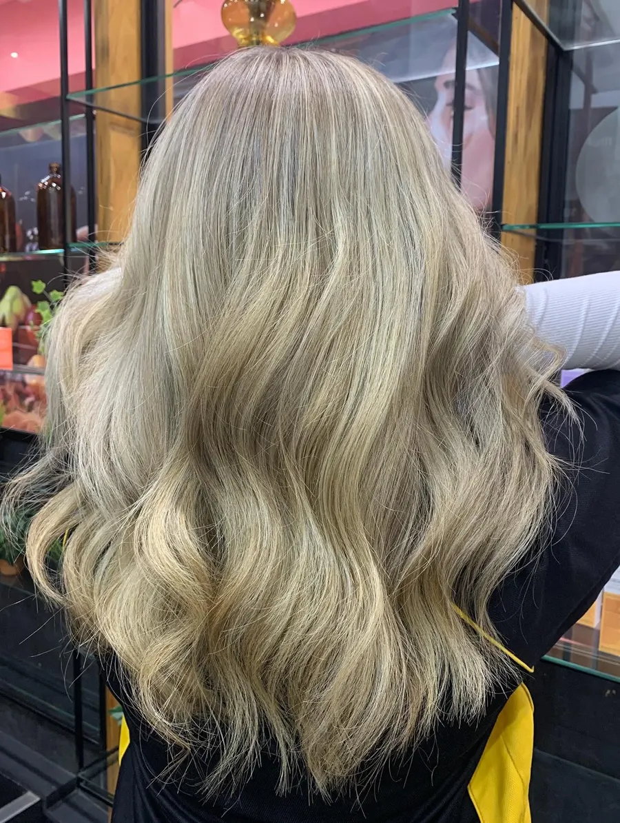 Ash blonde highlights through a long wavy blow-dry, by Roi Hair