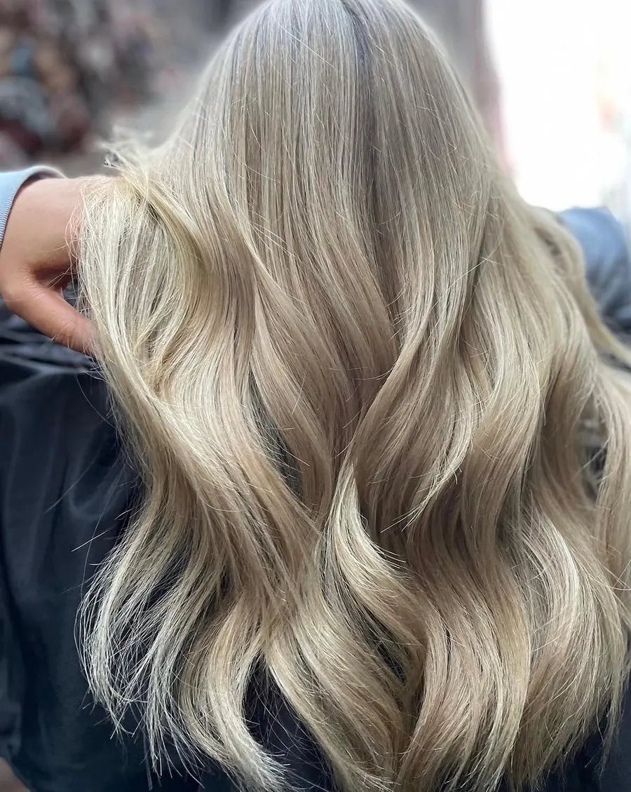 Cool ash blonde toned evenly through long waves, by Roi Hair