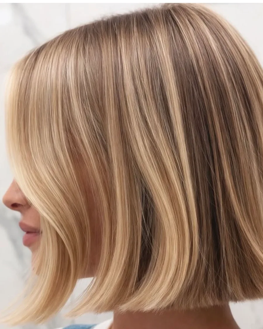 A sleek blonde one-length bob with a sharp blunt line and ribbon highlights, cut at Roi Hair