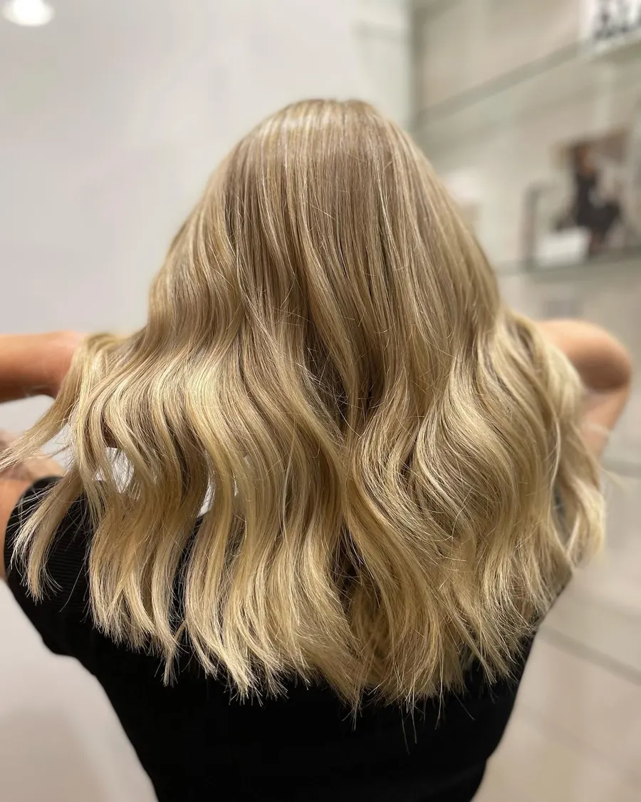 Golden blonde waves lifted evenly from root to end, by Roi Hair