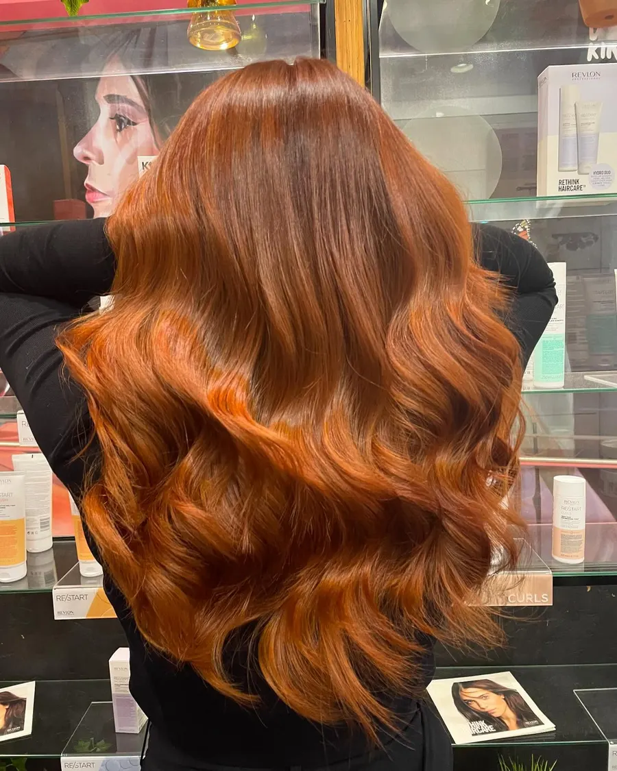 Long copper hair with warm waves, coloured at Roi Hair
