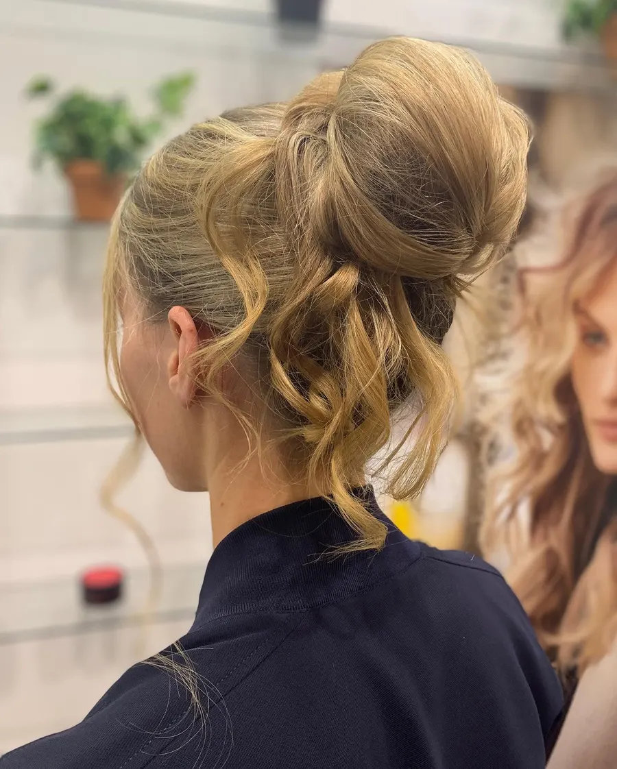 A soft blonde occasion upstyle with loose pieces left out, by Roi Hair